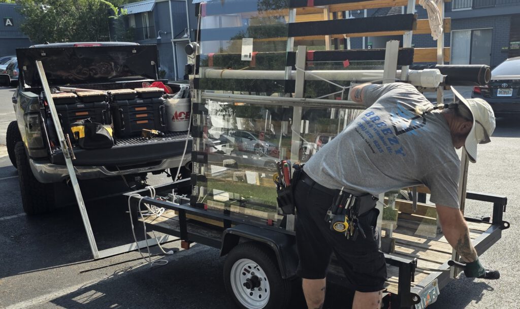 Breezy Glass technician loading glass on the work trailer