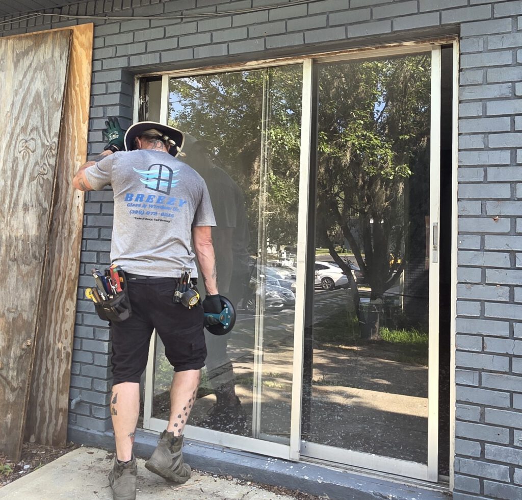 Breezy technician installing storefront glass for a local business